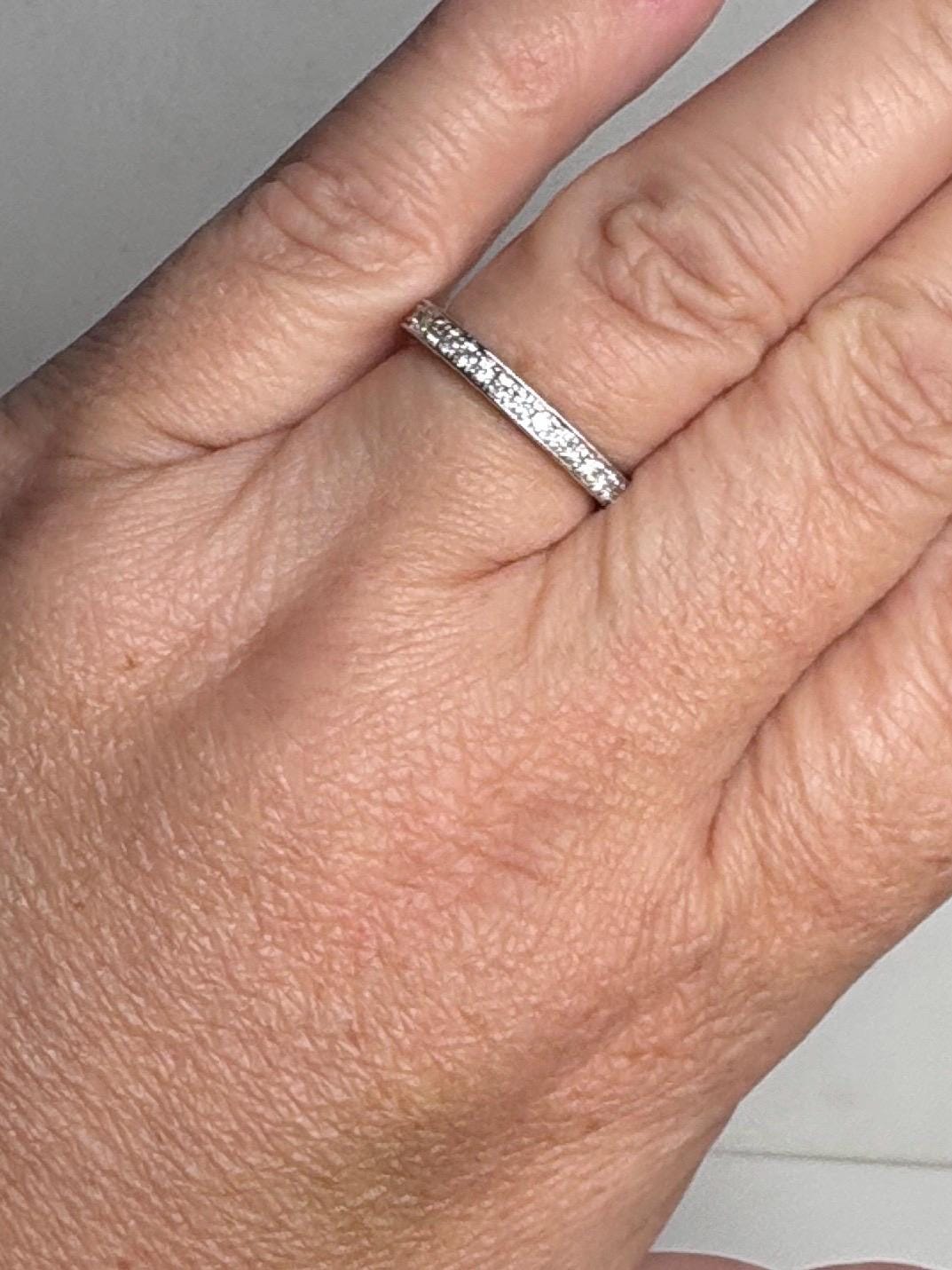 A thin 14k white gold band ring with small diamonds.