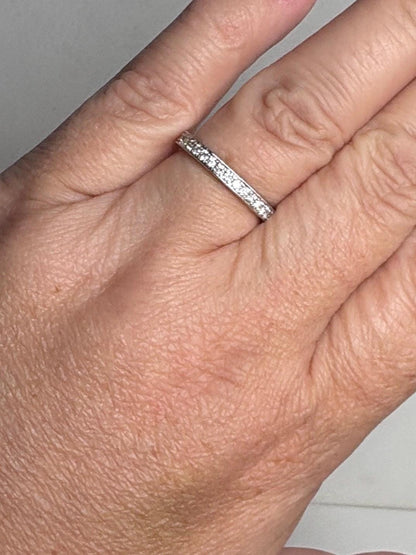 A thin 14k white gold band ring with small diamonds.