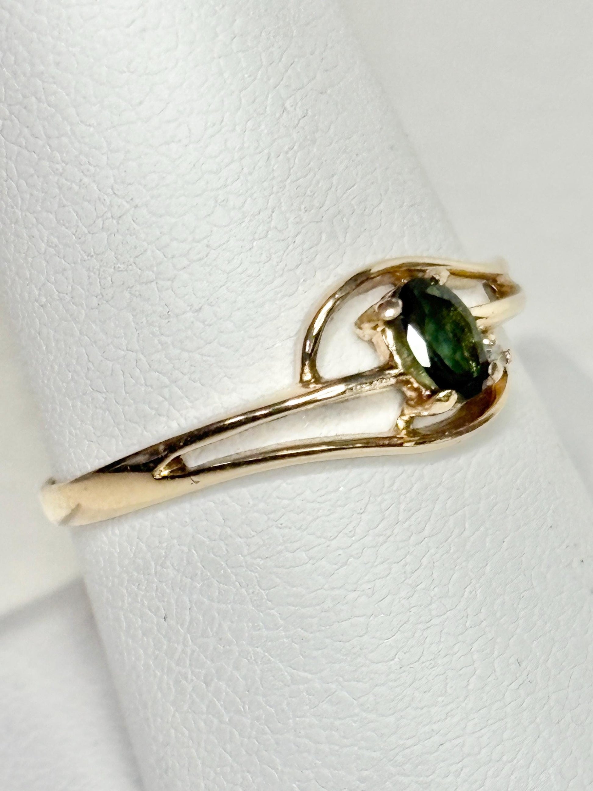 A 10k yellow gold ring with a green tourmaline and diamond accent.