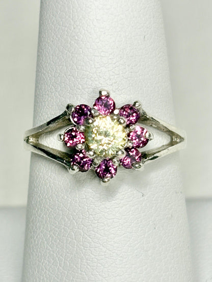 Sterling silver ring with a central yellow garnet surrounded by pink rhodolite garnets in a daisy halo design.
