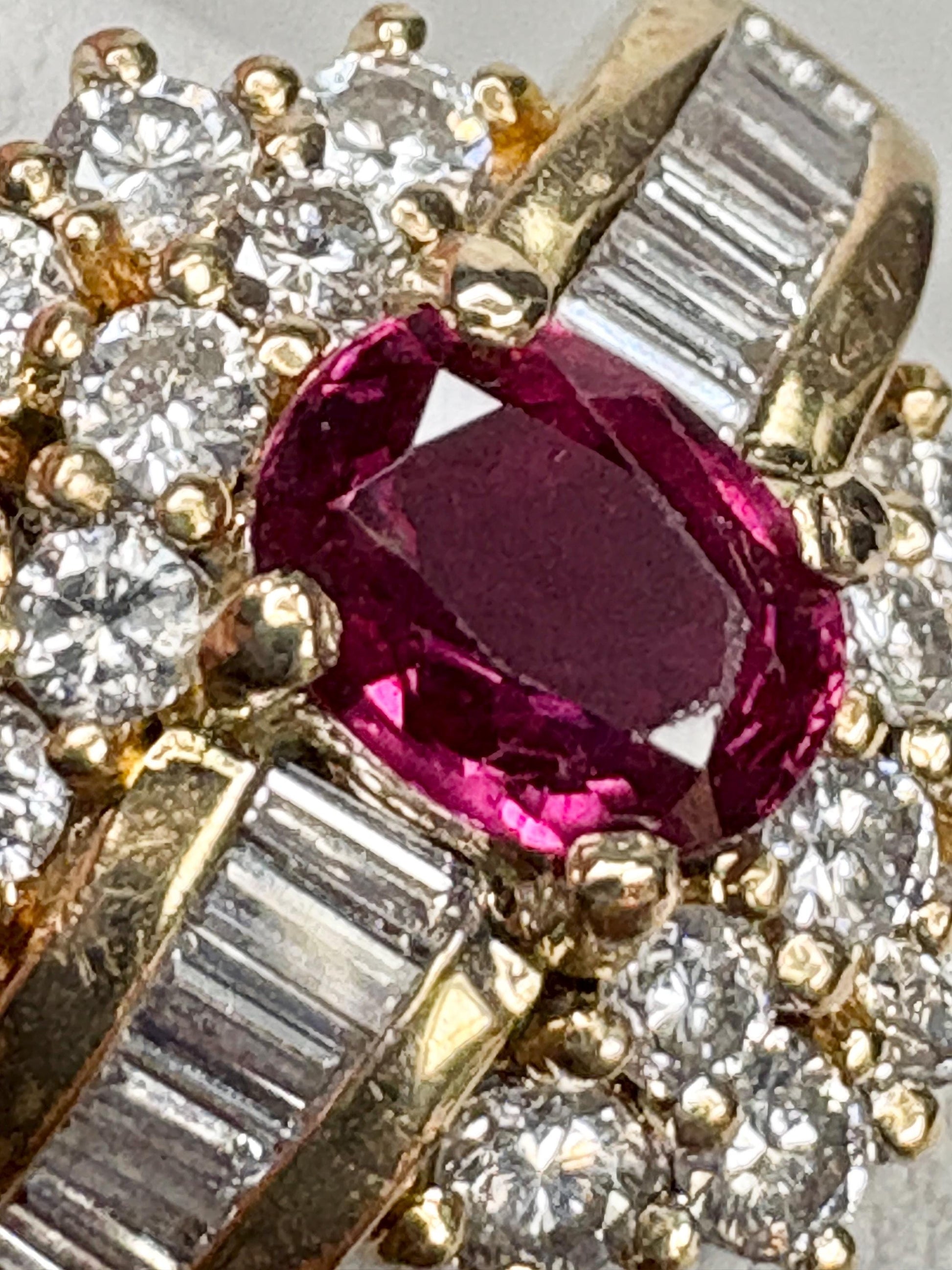 A vintage 18k gold cocktail ring with a central ruby and surrounding diamonds.