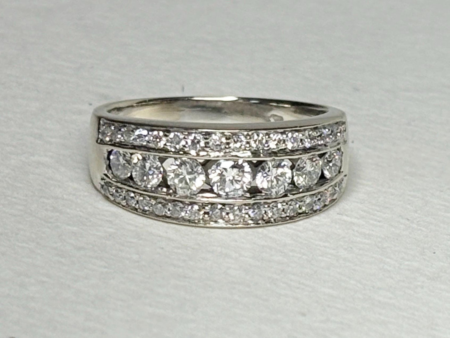 A 14k white gold anniversary band ring with channel and pave set diamonds.