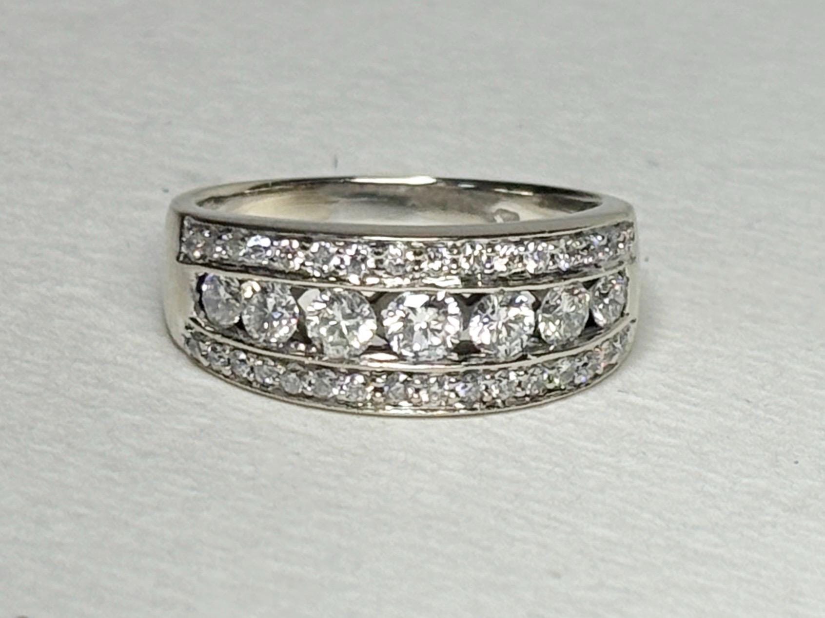 A 14k white gold anniversary band ring with channel and pave set diamonds.