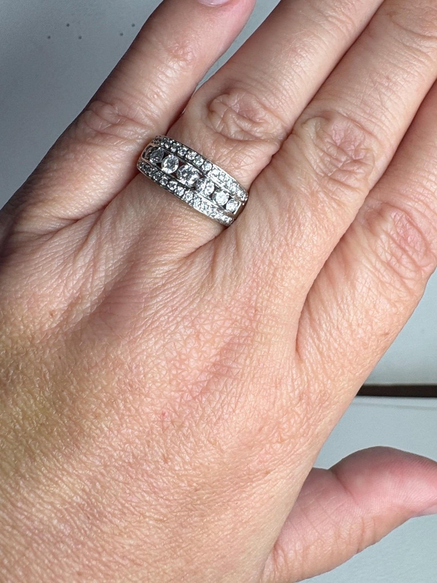A 14k white gold anniversary band ring with channel and pave set diamonds.