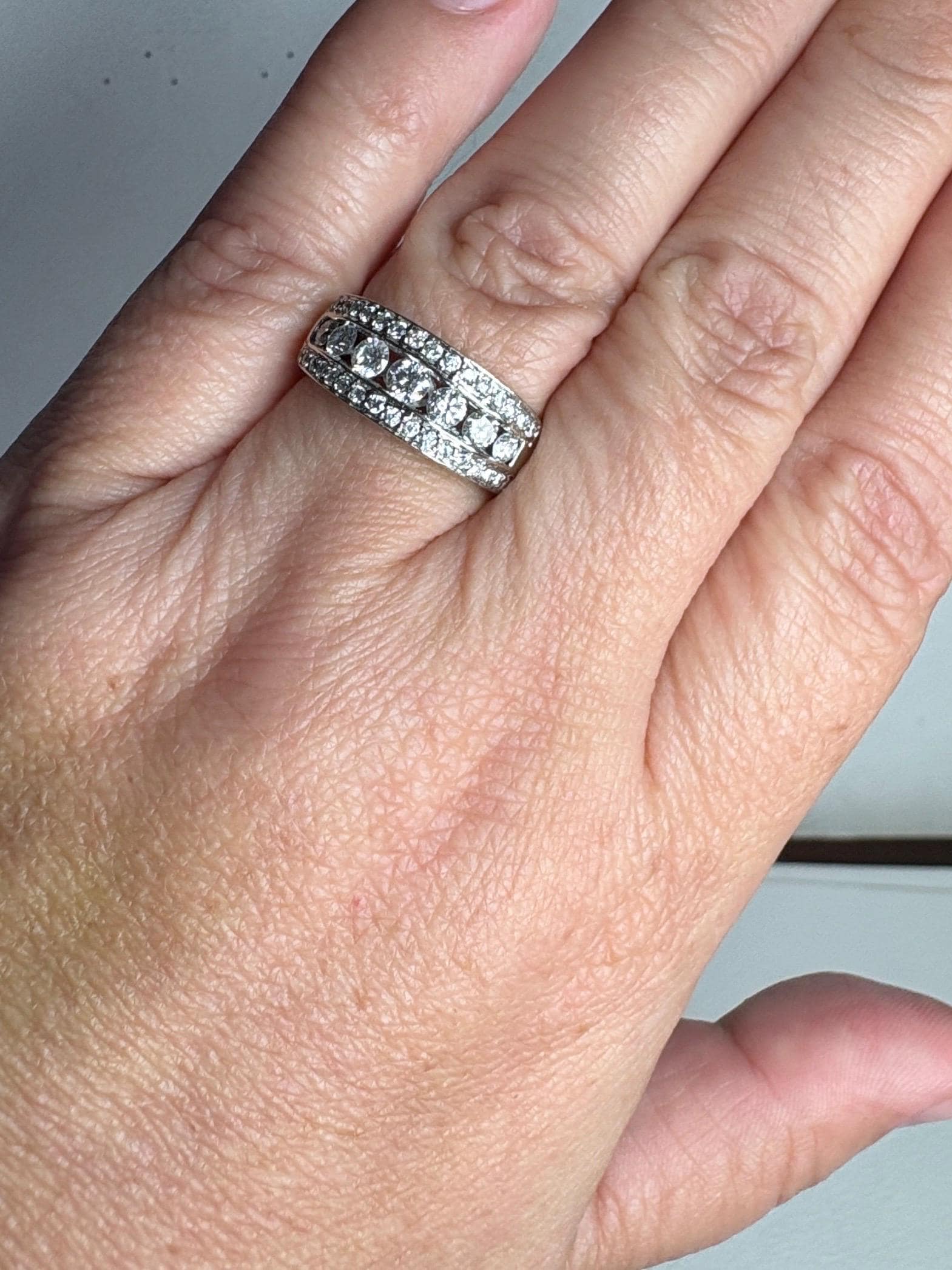 A 14k white gold anniversary band ring with channel and pave set diamonds.