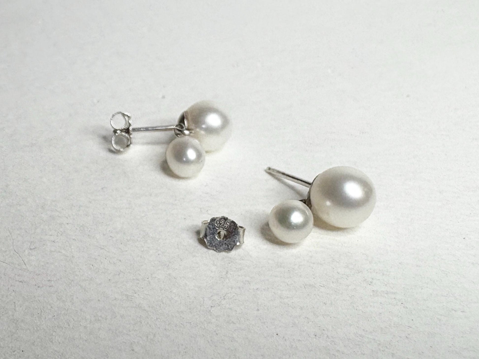 Sterling silver earrings with freshwater cultured pearls in a dangle drop design.