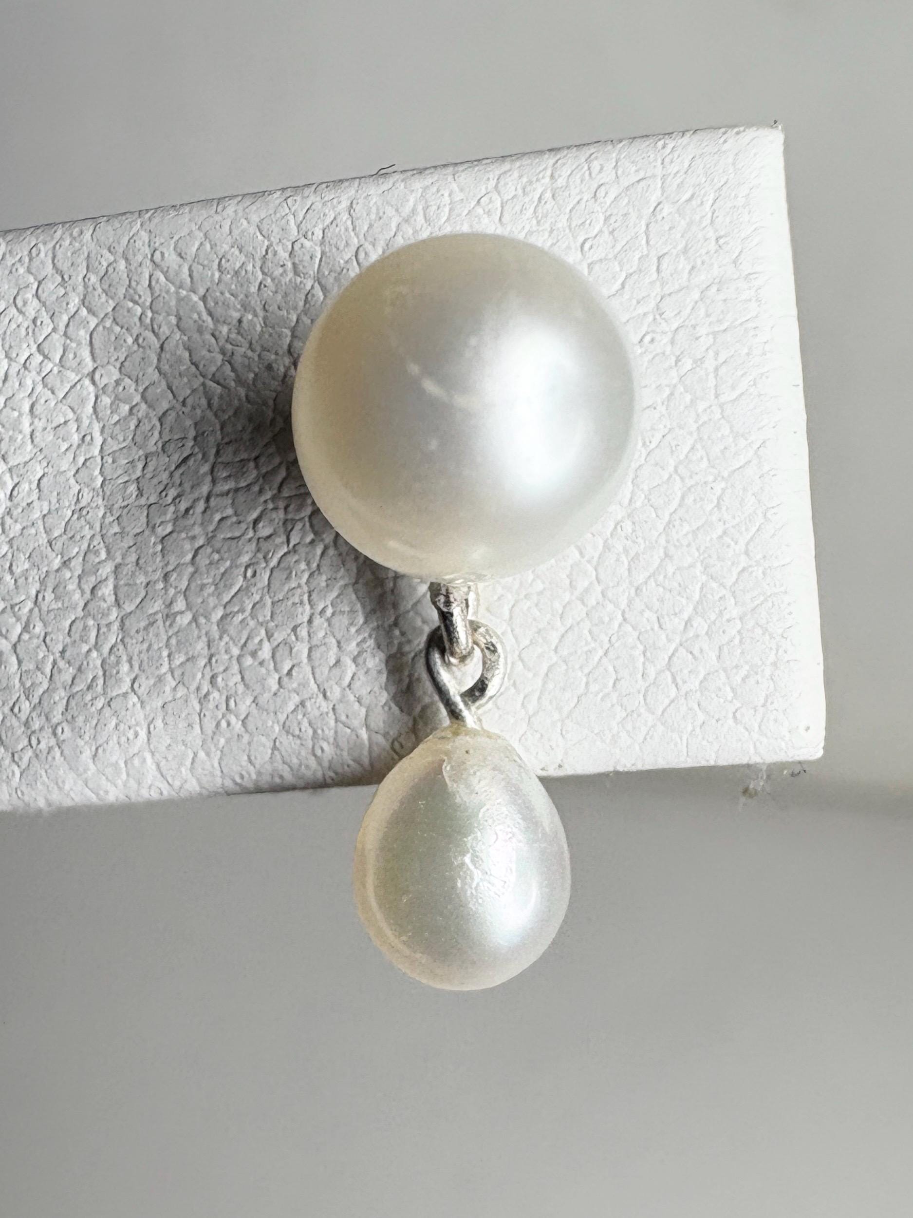 Sterling silver earrings with round freshwater pearls and a dangling teardrop pearl.