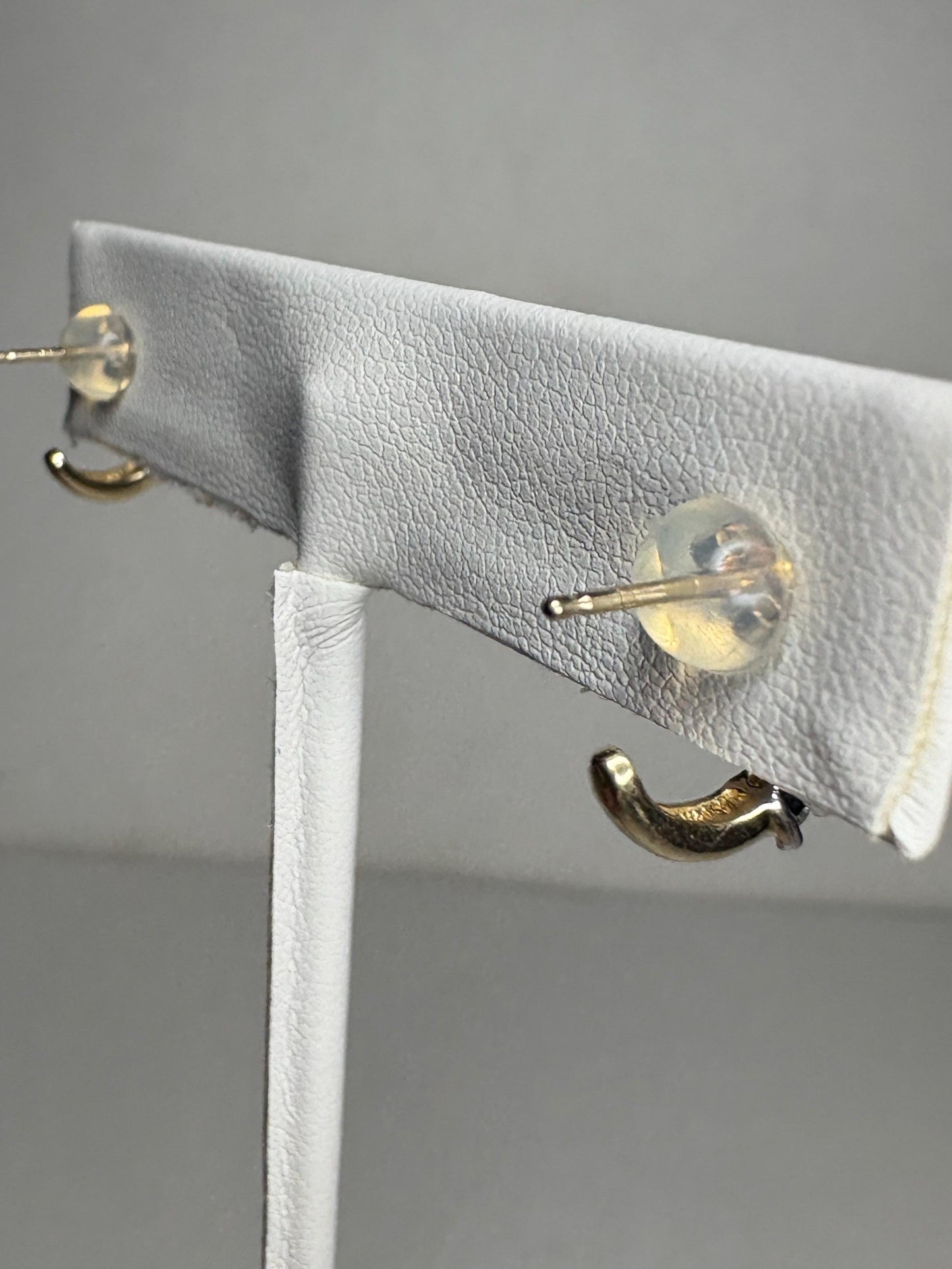 Tiny 14k gold partial hoop stud earrings with diamonds.