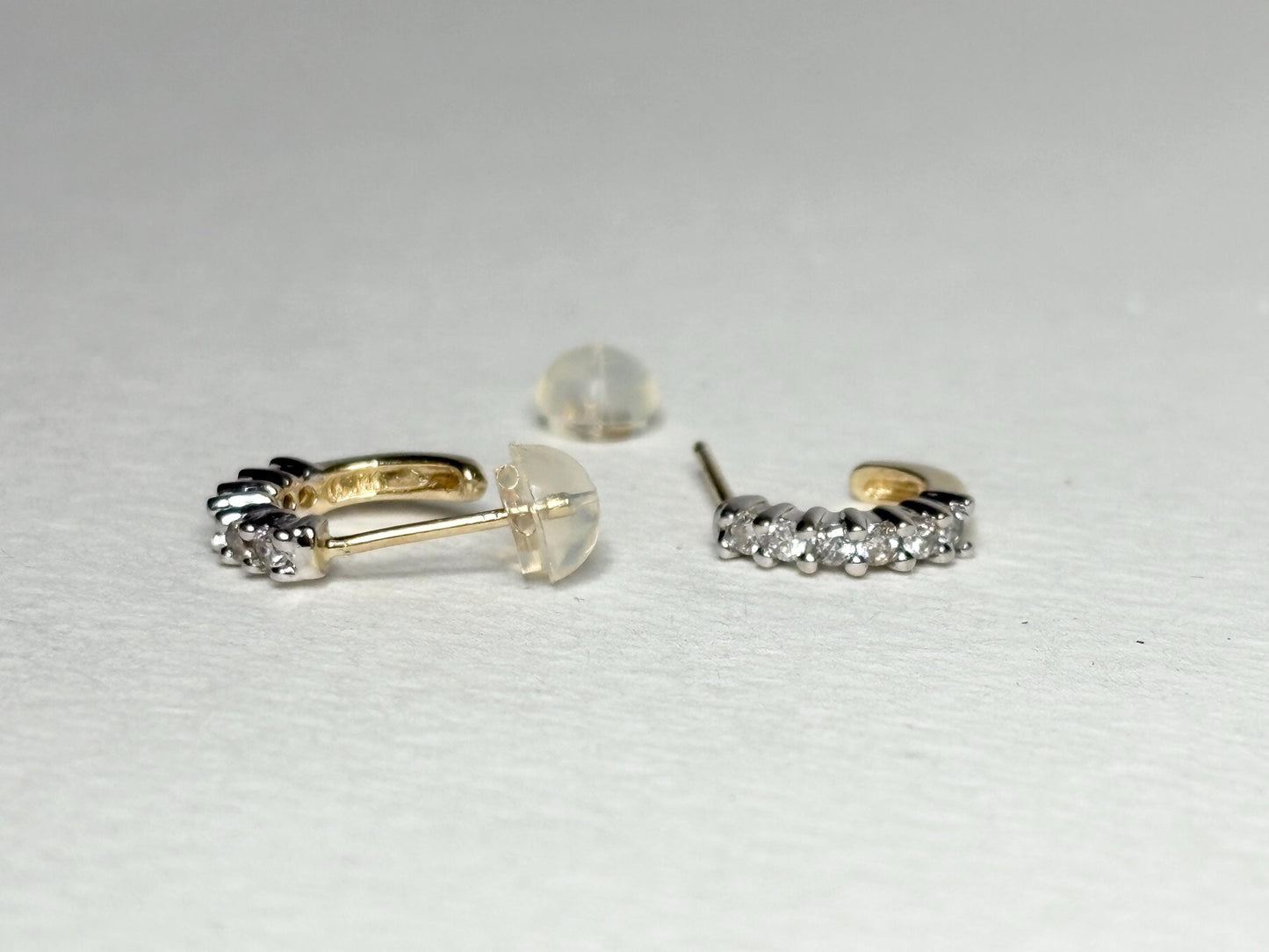 Tiny 14k gold hoop earrings with natural diamonds and silicone backs.