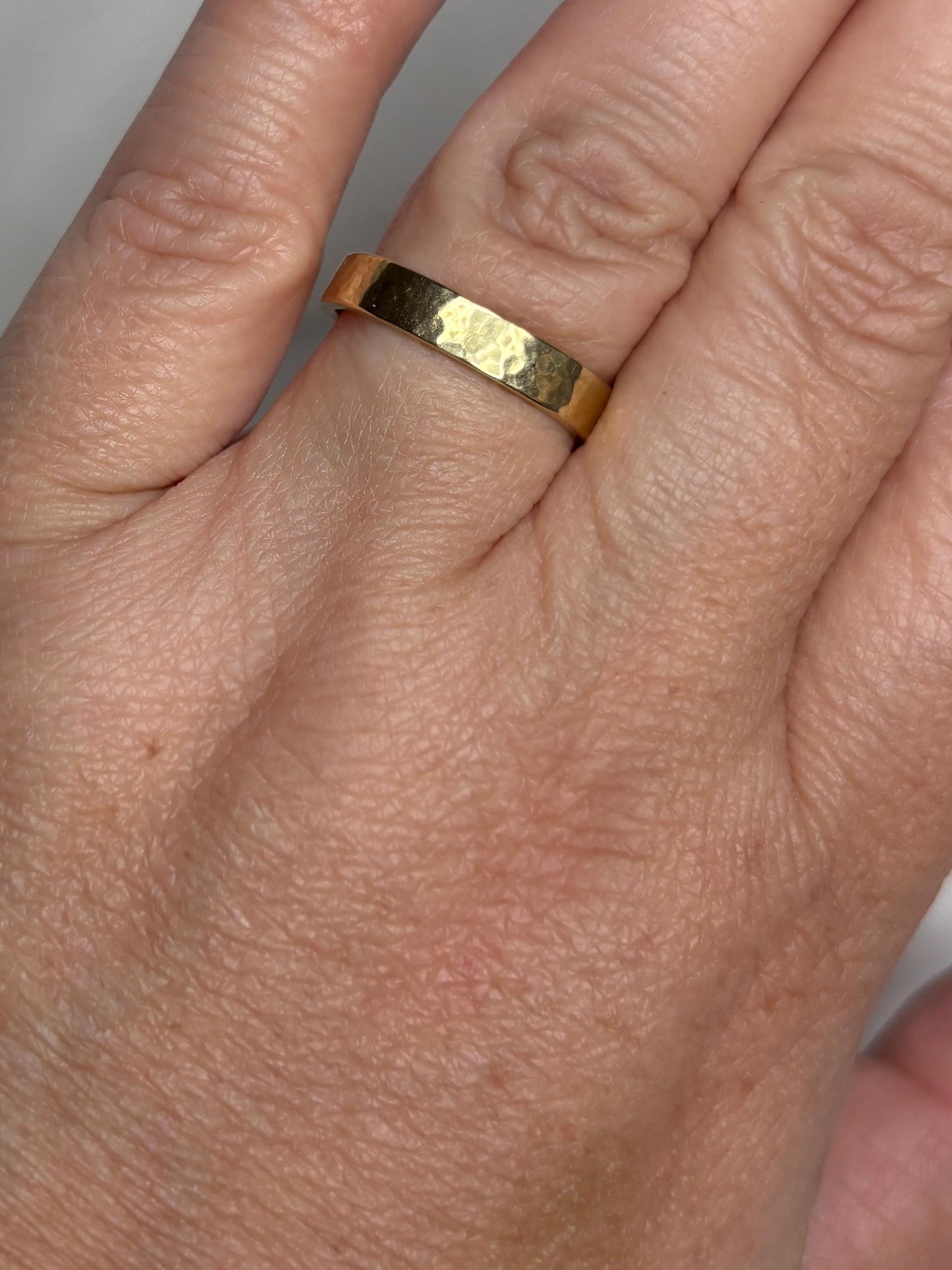 Solid 18k yellow gold hammered finish square band ring.
