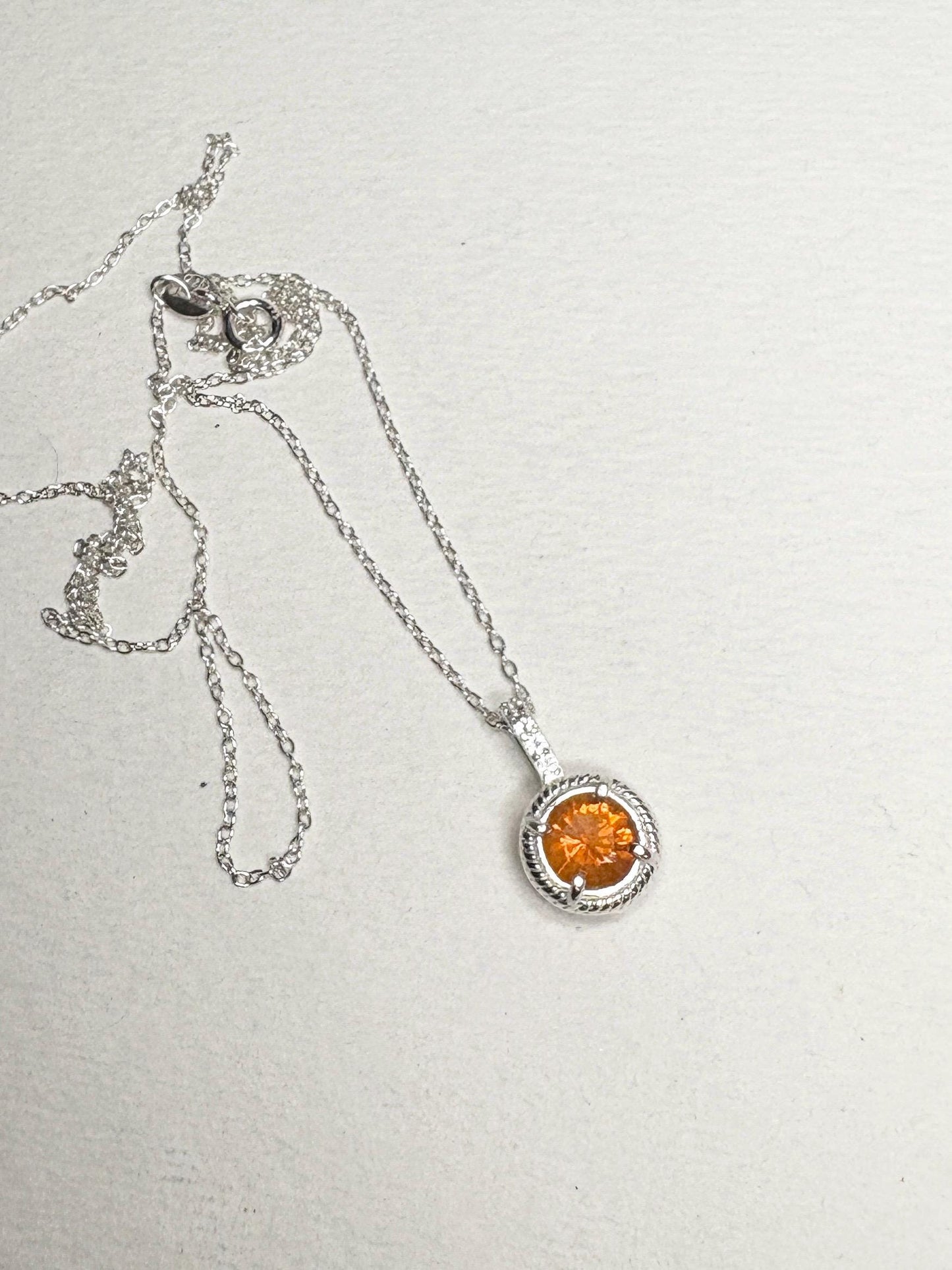 Sterling silver necklace with an orange fire opal and white topaz pendant.