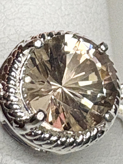 Sterling silver ring with a round Oregon sunstone and white topaz accents.