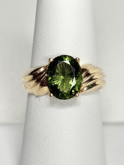 Oval faceted moldavite ring in solid 14k gold.