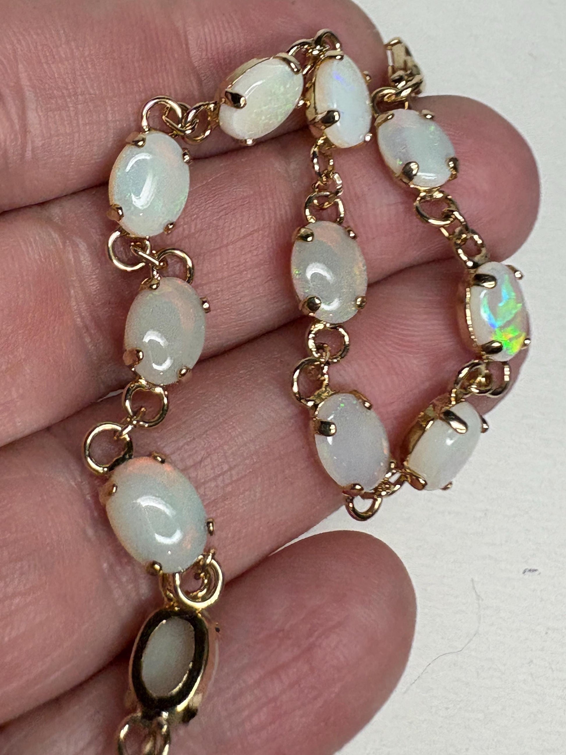 Gold plated tennis bracelet with 11 oval natural opals.