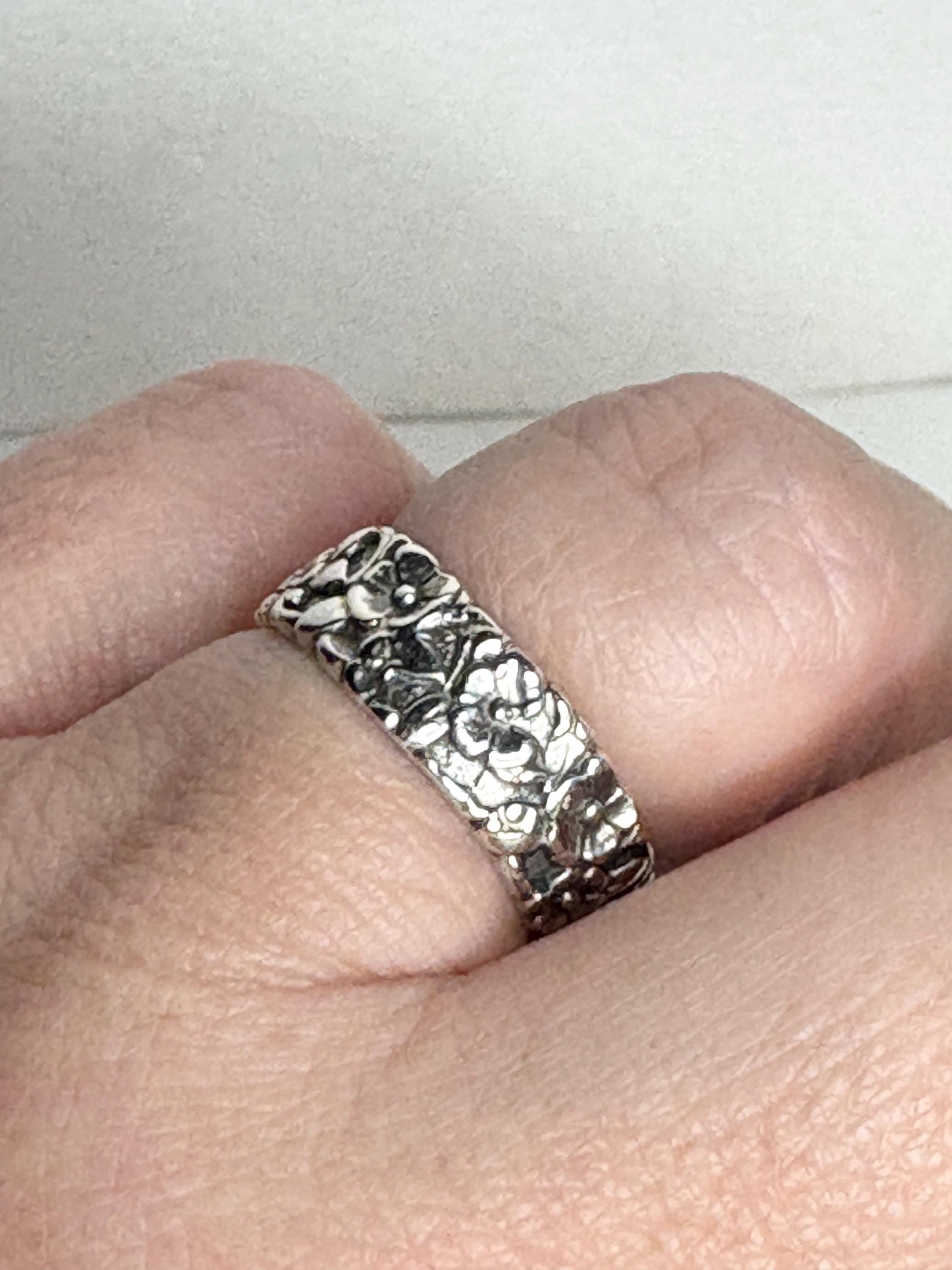 Sterling silver eternity band ring with a forget-me-not floral design.