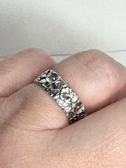 Sterling silver eternity band ring with a forget-me-not floral design.