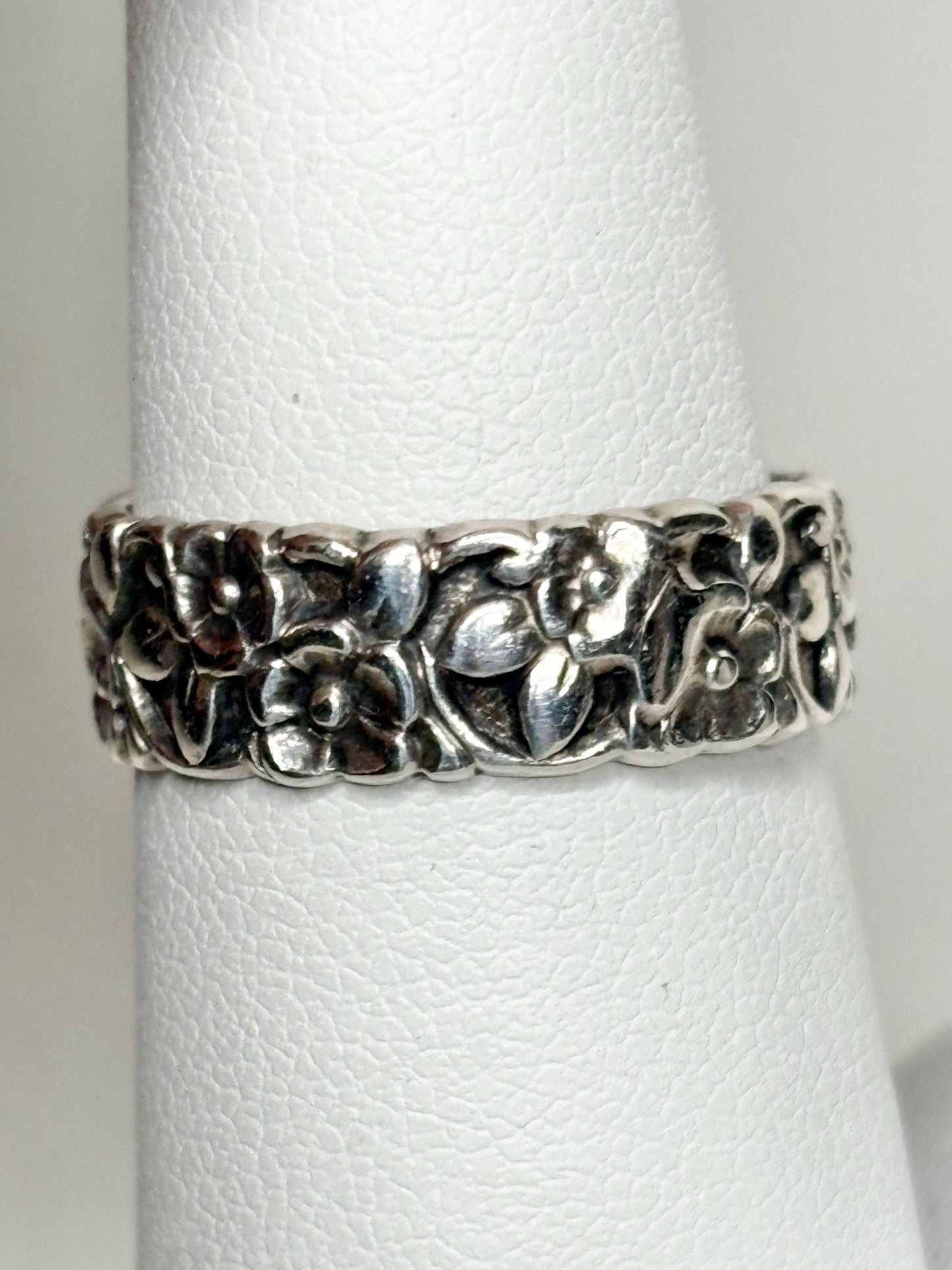 Sterling silver eternity band ring with a forget-me-not floral design.