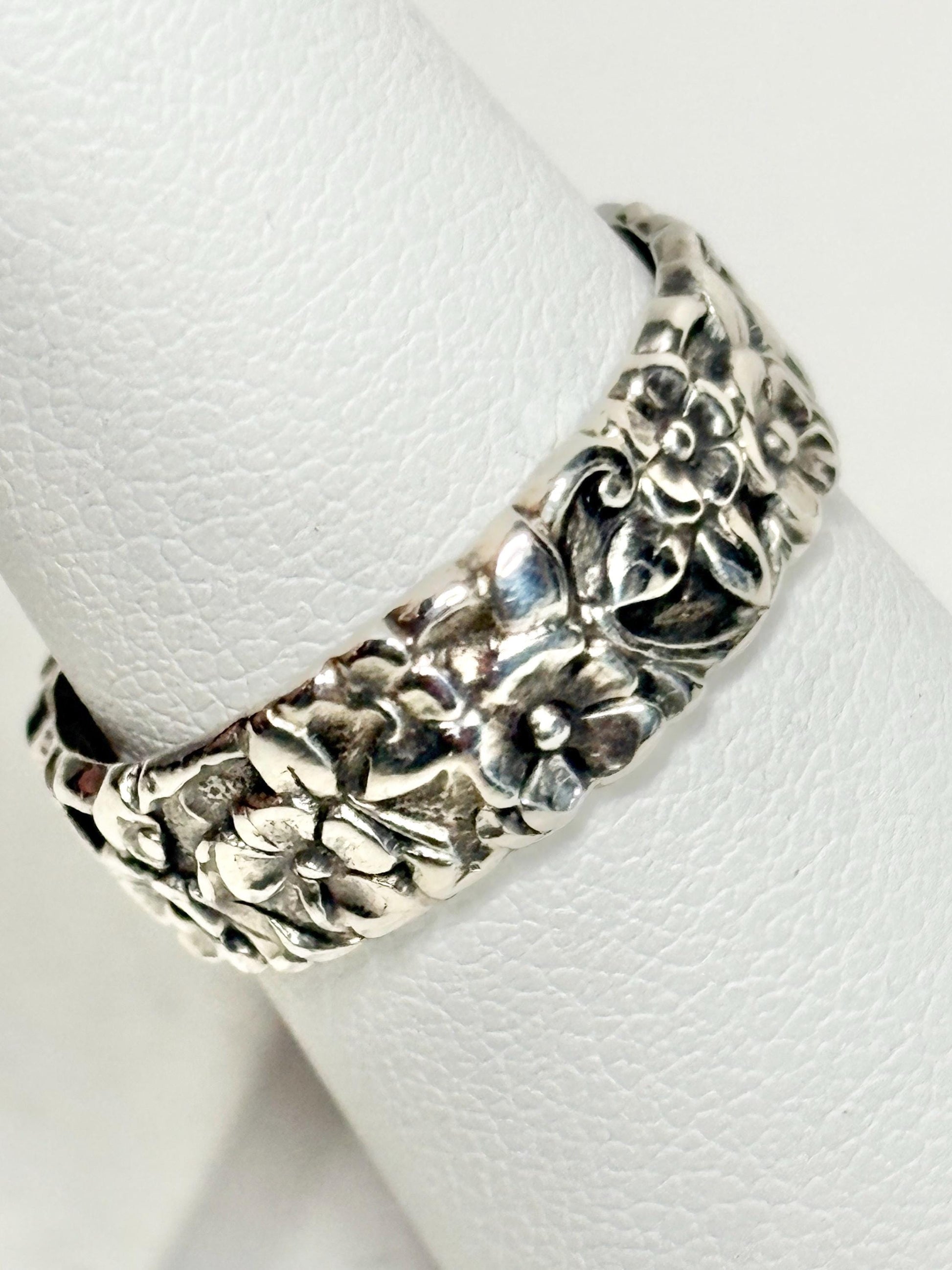 Sterling silver eternity band ring with a forget-me-not floral design.