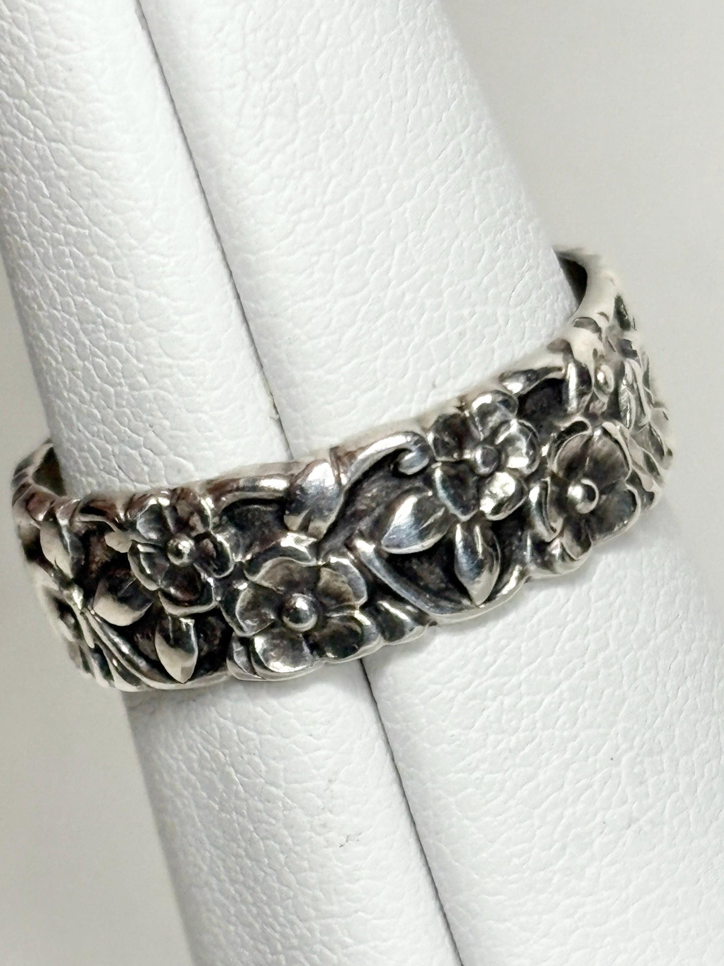 Sterling silver eternity band ring with forget-me-not floral design.