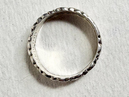 Sterling silver eternity band ring with forget-me-not floral engraving.