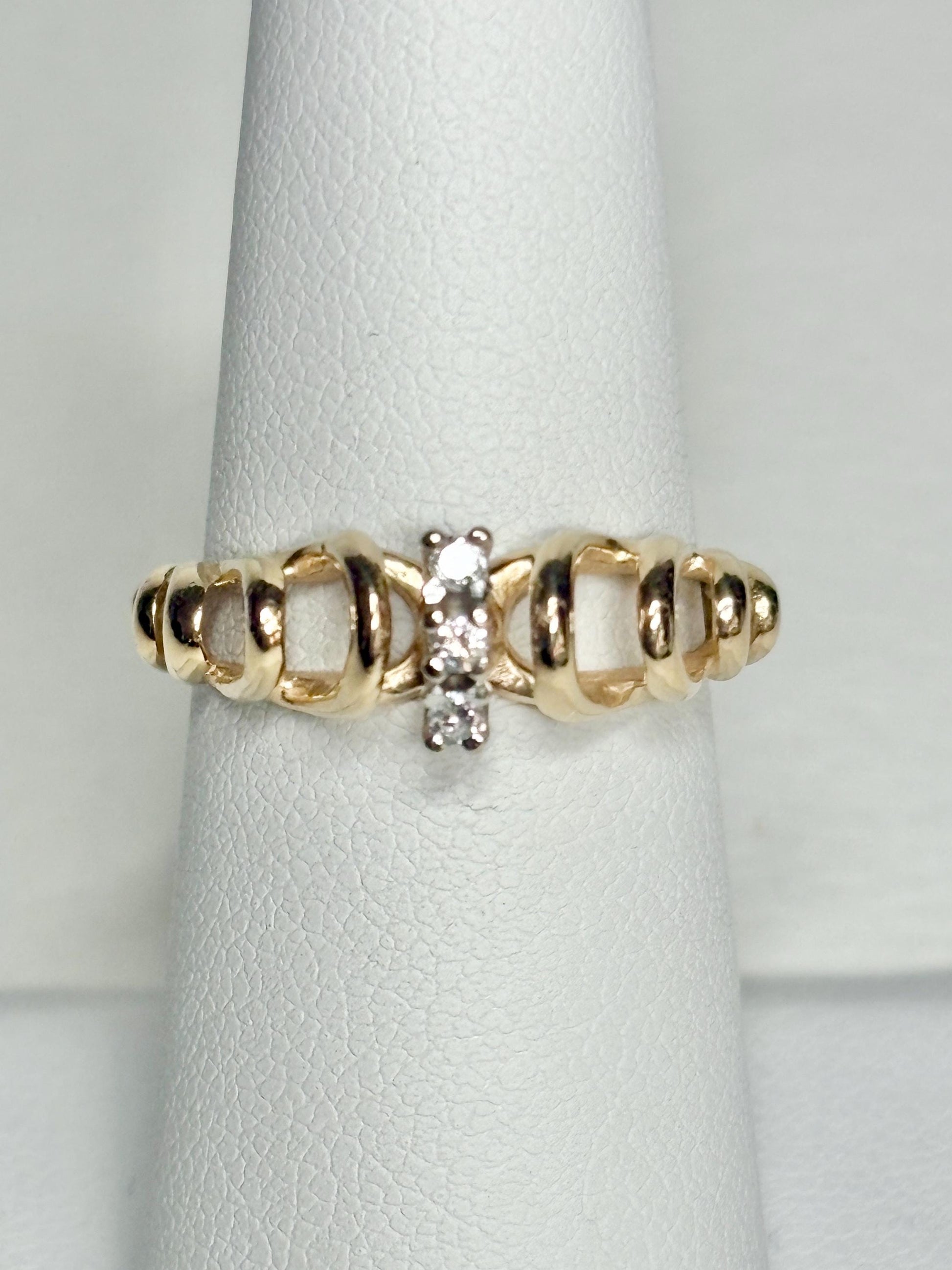 Vintage 14k gold ring with ribbon loops and three diamonds.