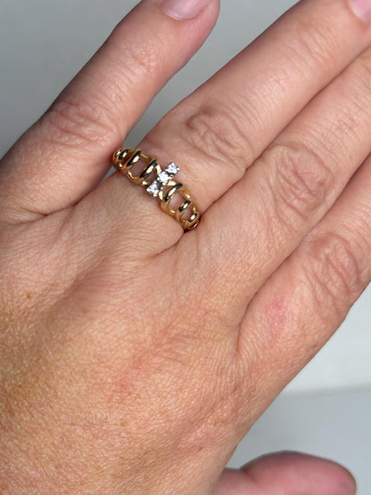 Vintage 14k gold ring with three diamonds and a ribbon loop design.