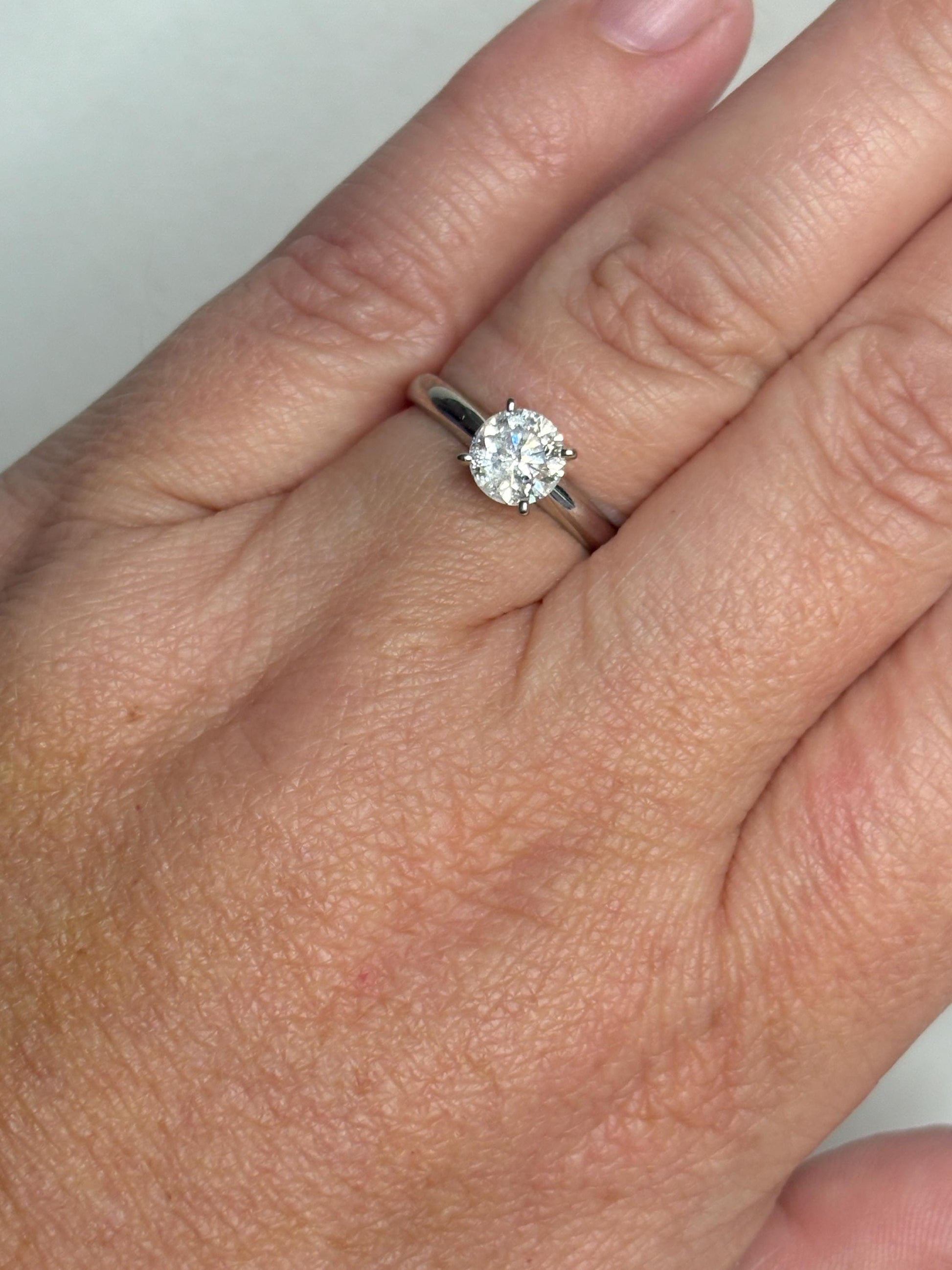 A 1ct round diamond solitaire ring in a 10k white gold band.