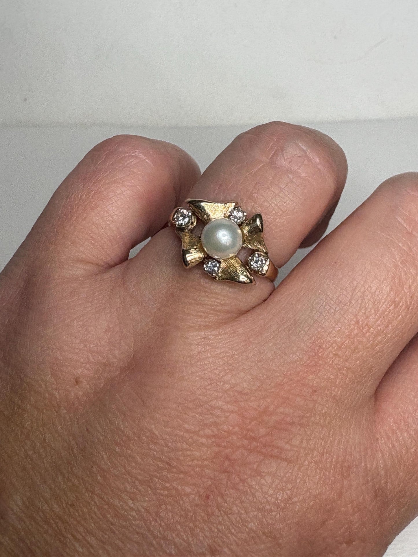 A 14k gold ring with a pearl and diamonds.