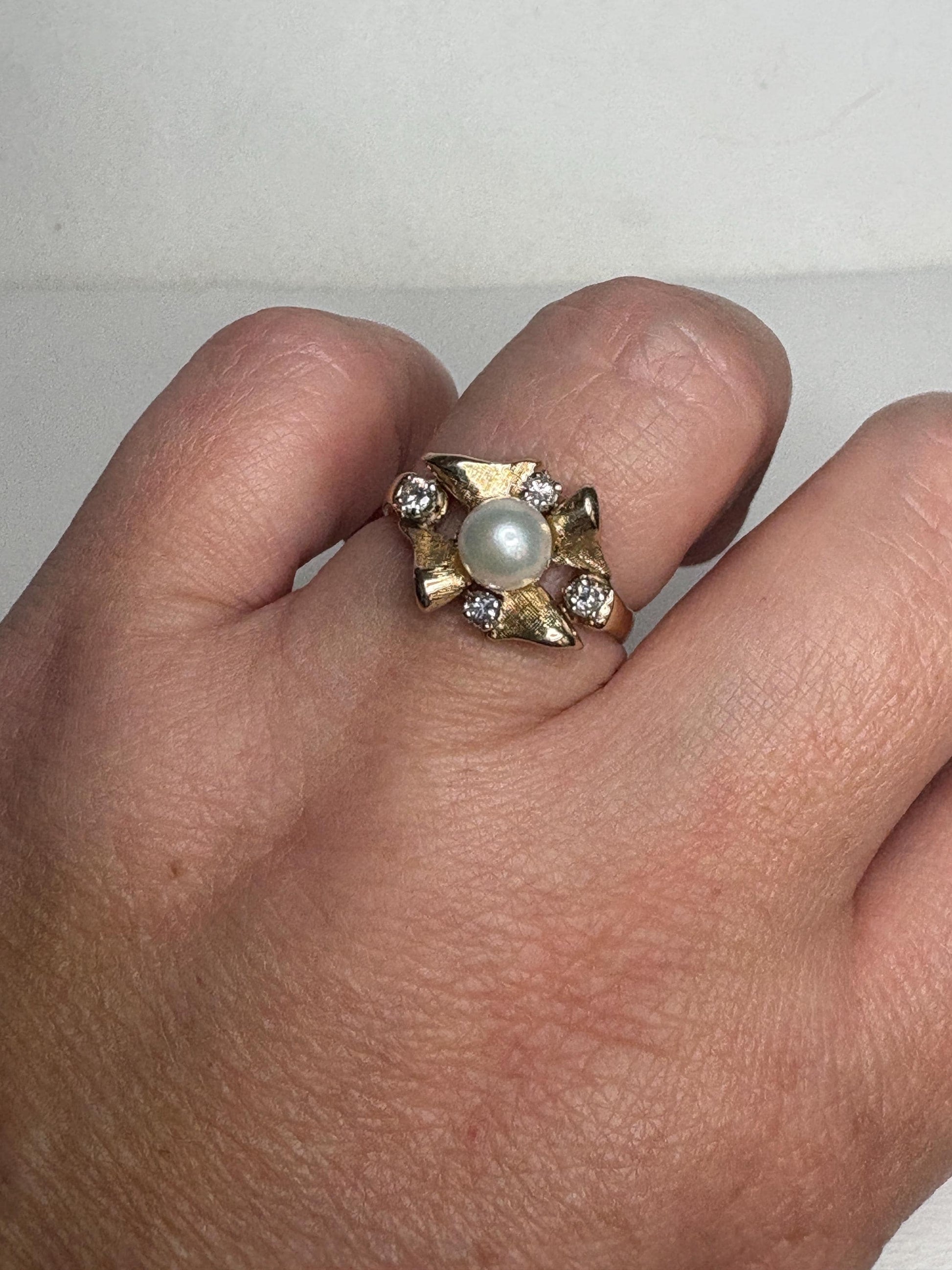 A 14k gold ring with a pearl and diamonds.