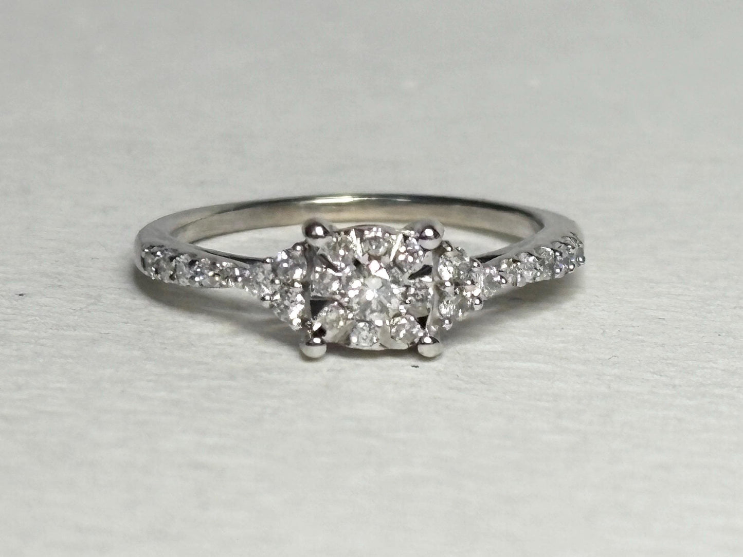 A 14k white gold ring with a squared diamond cluster center and diamond accents.