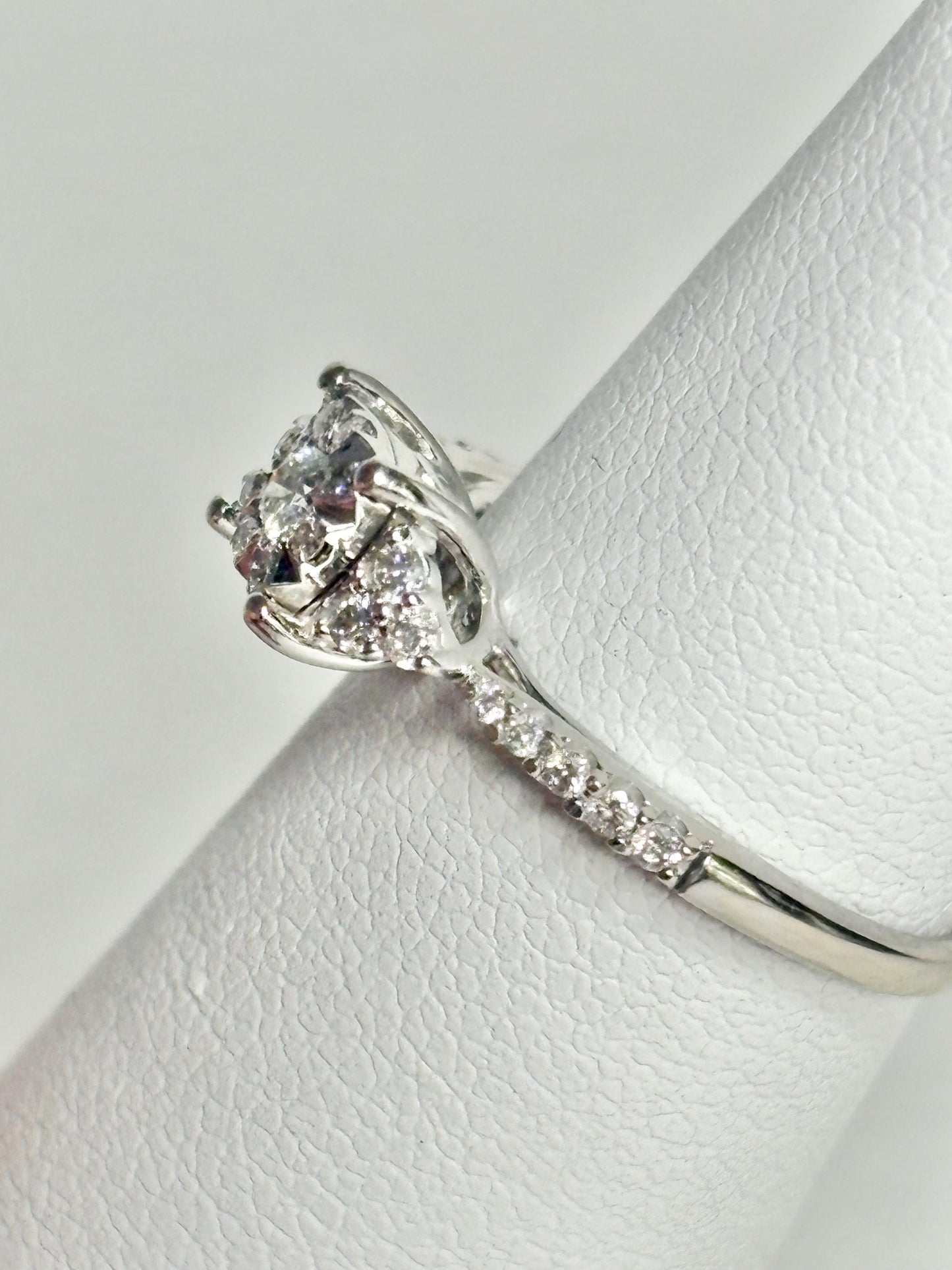 A 14k white gold ring with a squared diamond halo cluster and a diamond-accented band.