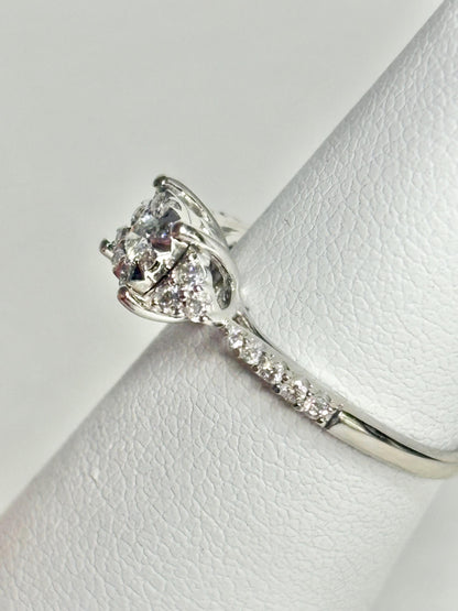 A 14k white gold ring with a squared diamond halo cluster and a diamond-accented band.