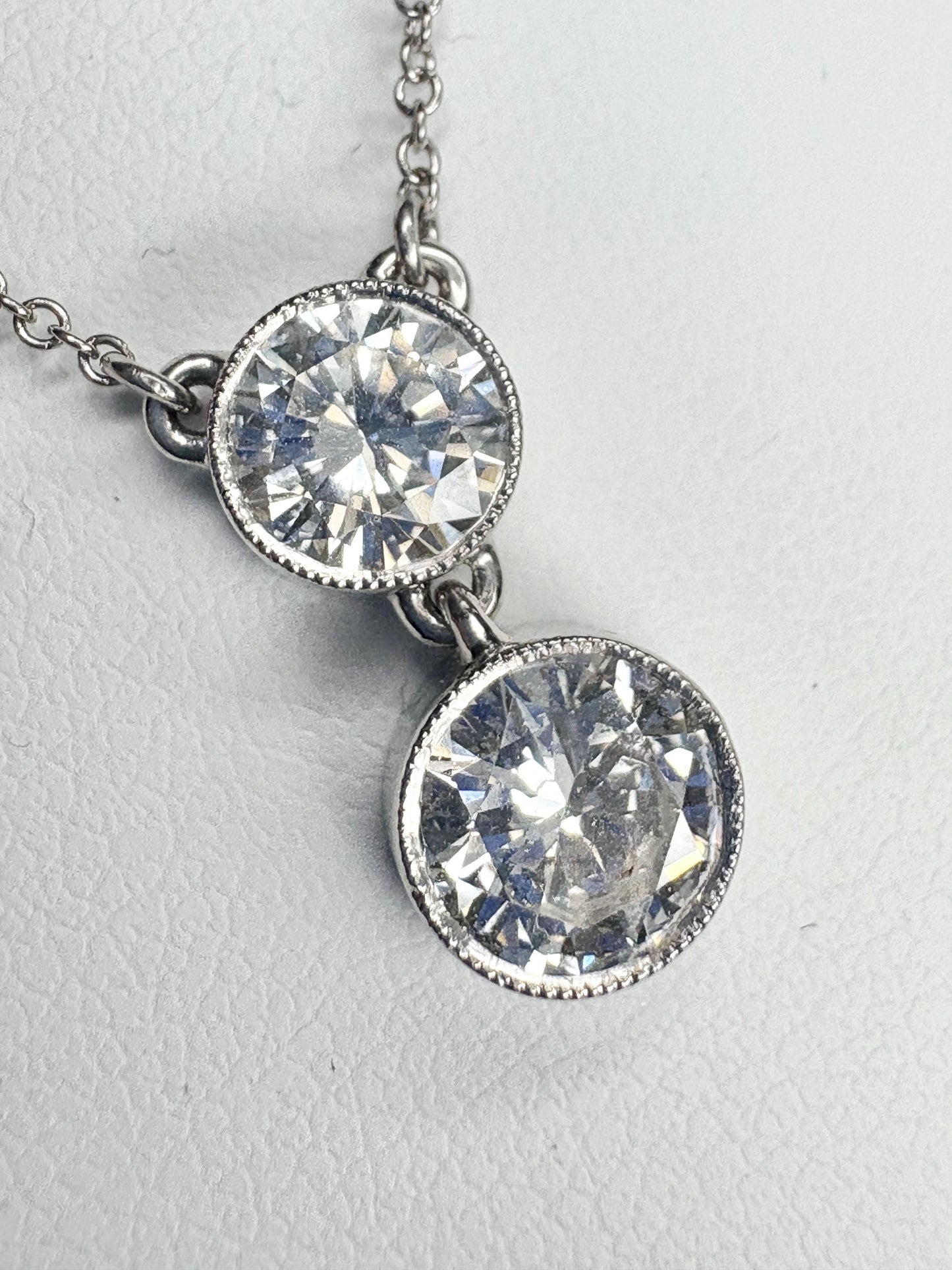 A 14k white gold necklace with two bezel-set natural diamonds.