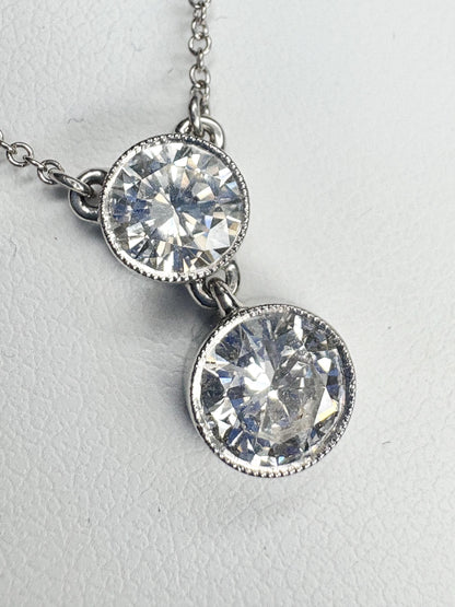 A 14k white gold necklace with two bezel-set natural diamonds.