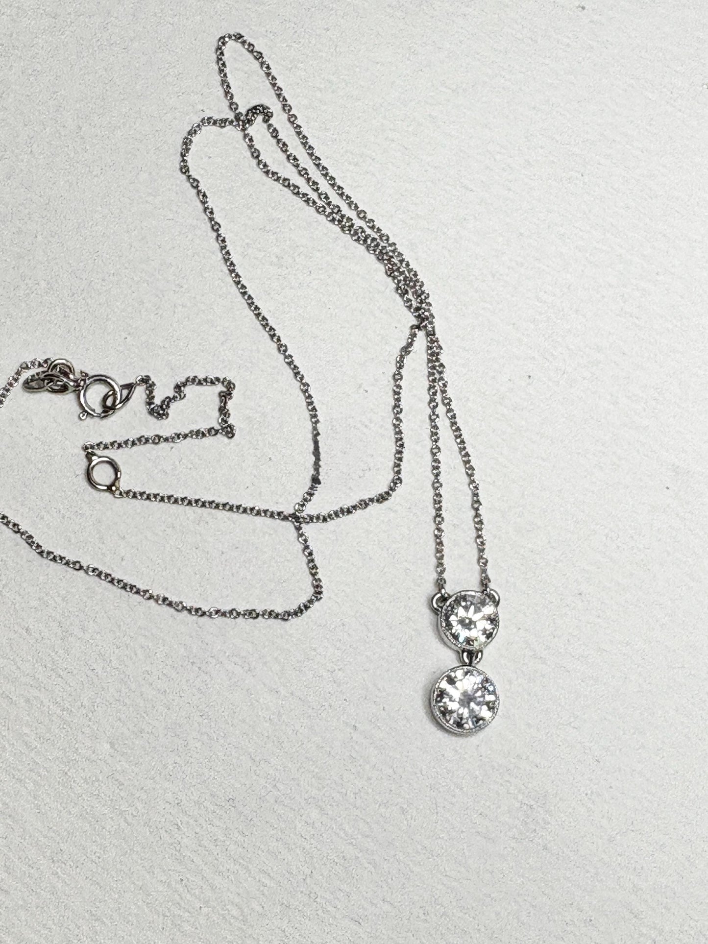 14k white gold necklace with two bezel-set solitaire diamonds on an adjustable chain.