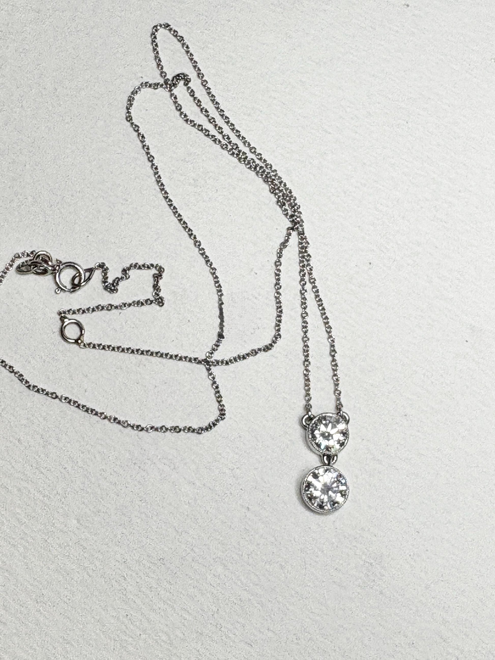 14k white gold necklace with two bezel-set solitaire diamonds on an adjustable chain.