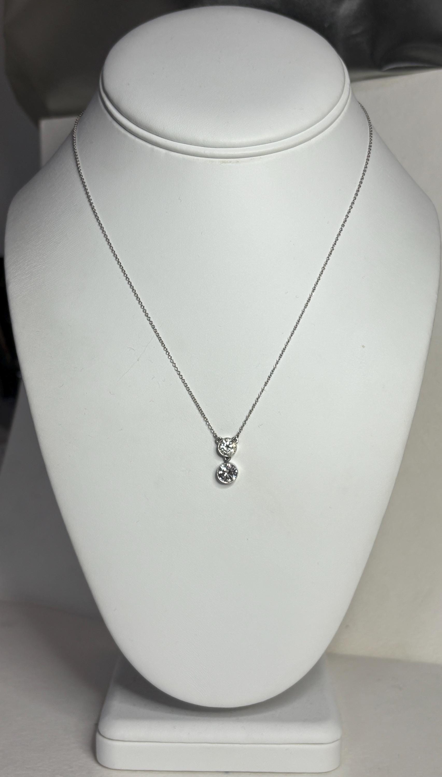 14k white gold necklace with two round diamonds on an adjustable chain.