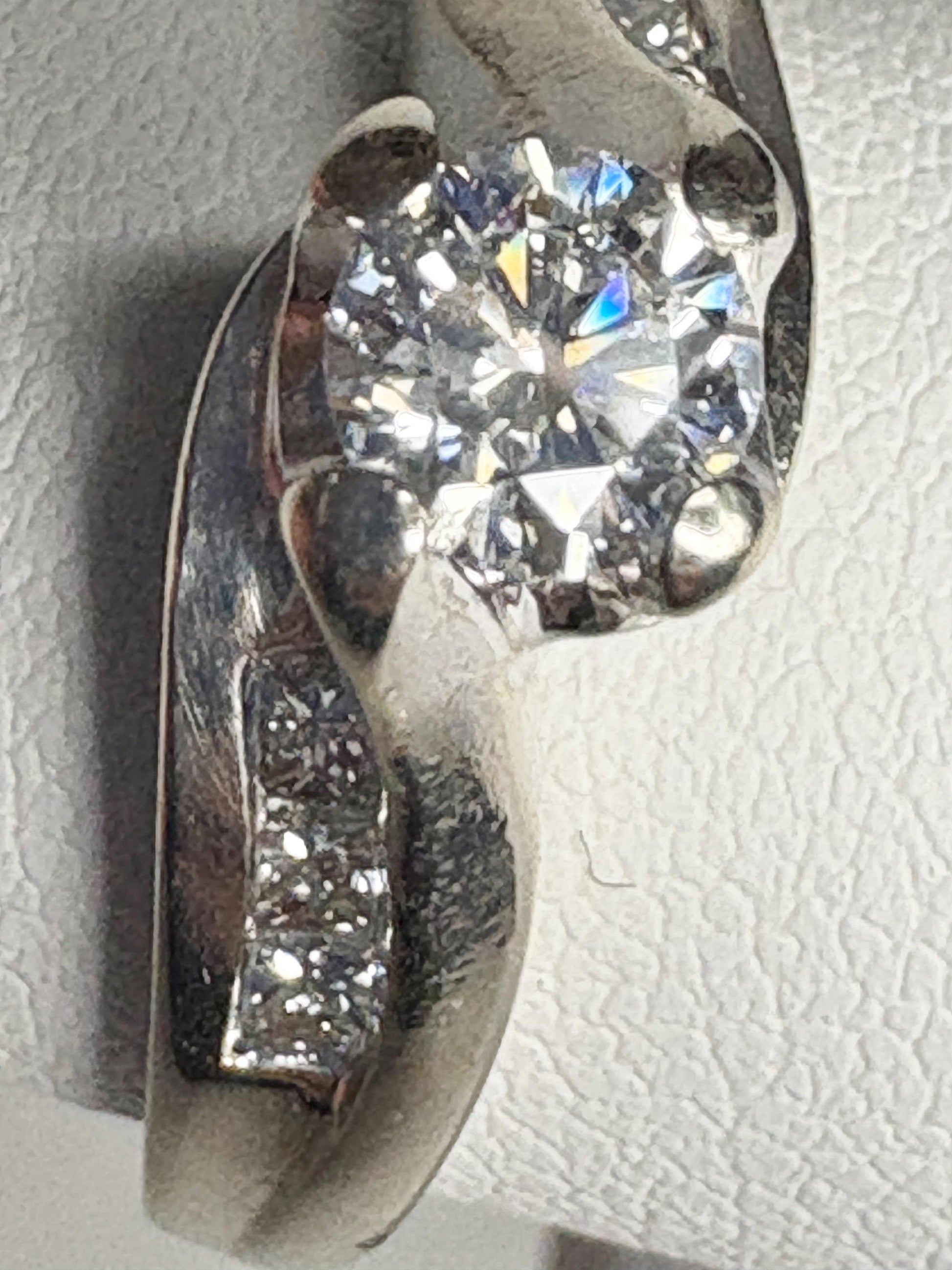 A vintage 14k white gold engagement ring with a central diamond and channel-set princess cut diamonds.