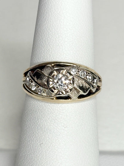 Mid-century two-tone 14k gold ring with a central diamond and smaller side diamonds.
