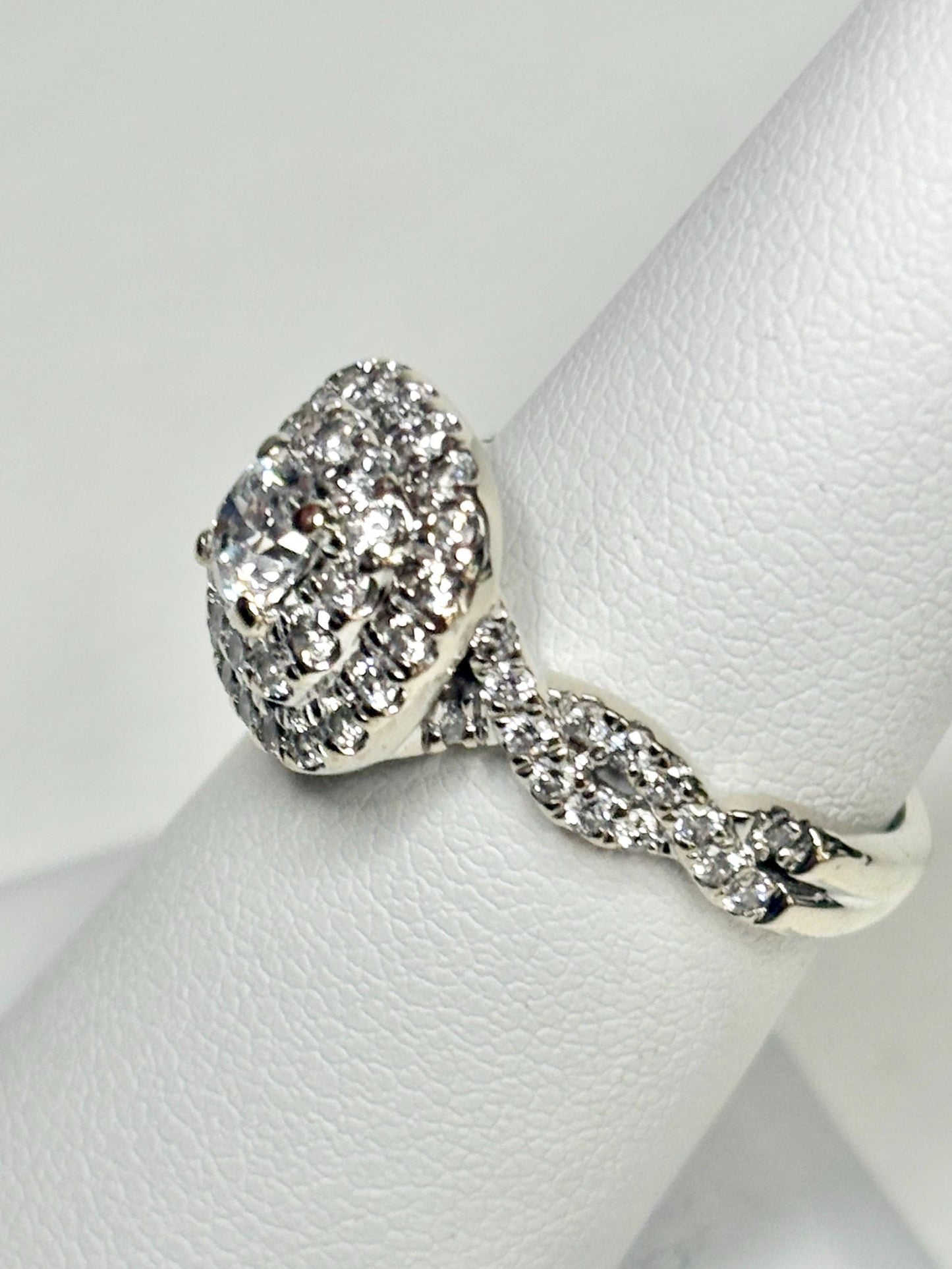 A 14k white gold ring with a central diamond and a double halo of smaller diamonds.