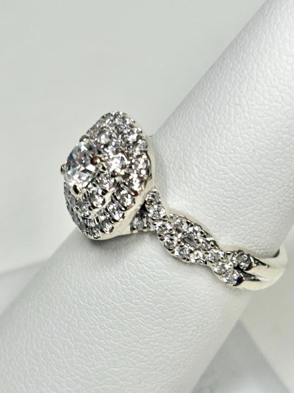 A 14k white gold ring with a central diamond and a double halo of smaller diamonds.