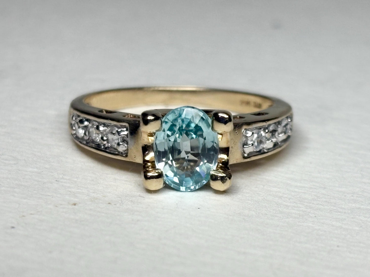 Oval blue zircon and clear side stone two-tone 14k gold ring.