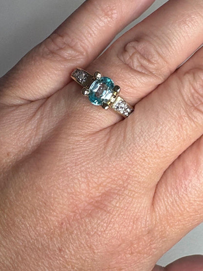 Oval blue zircon and clear stone two-tone 14k gold ring.