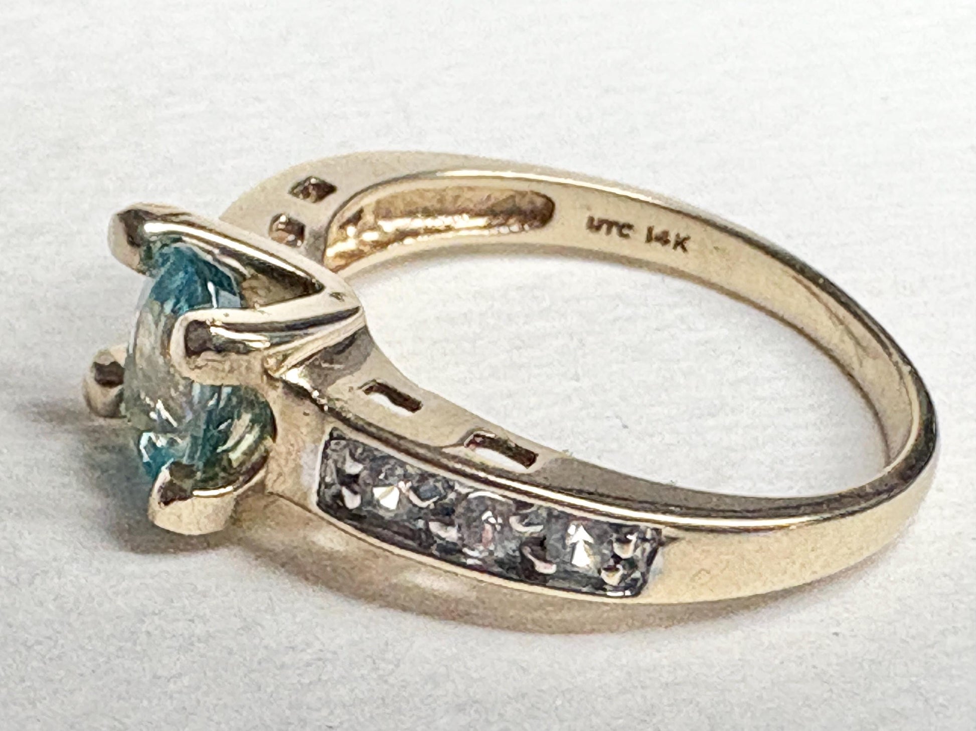 14k gold ring with a blue oval zircon and clear side stones.