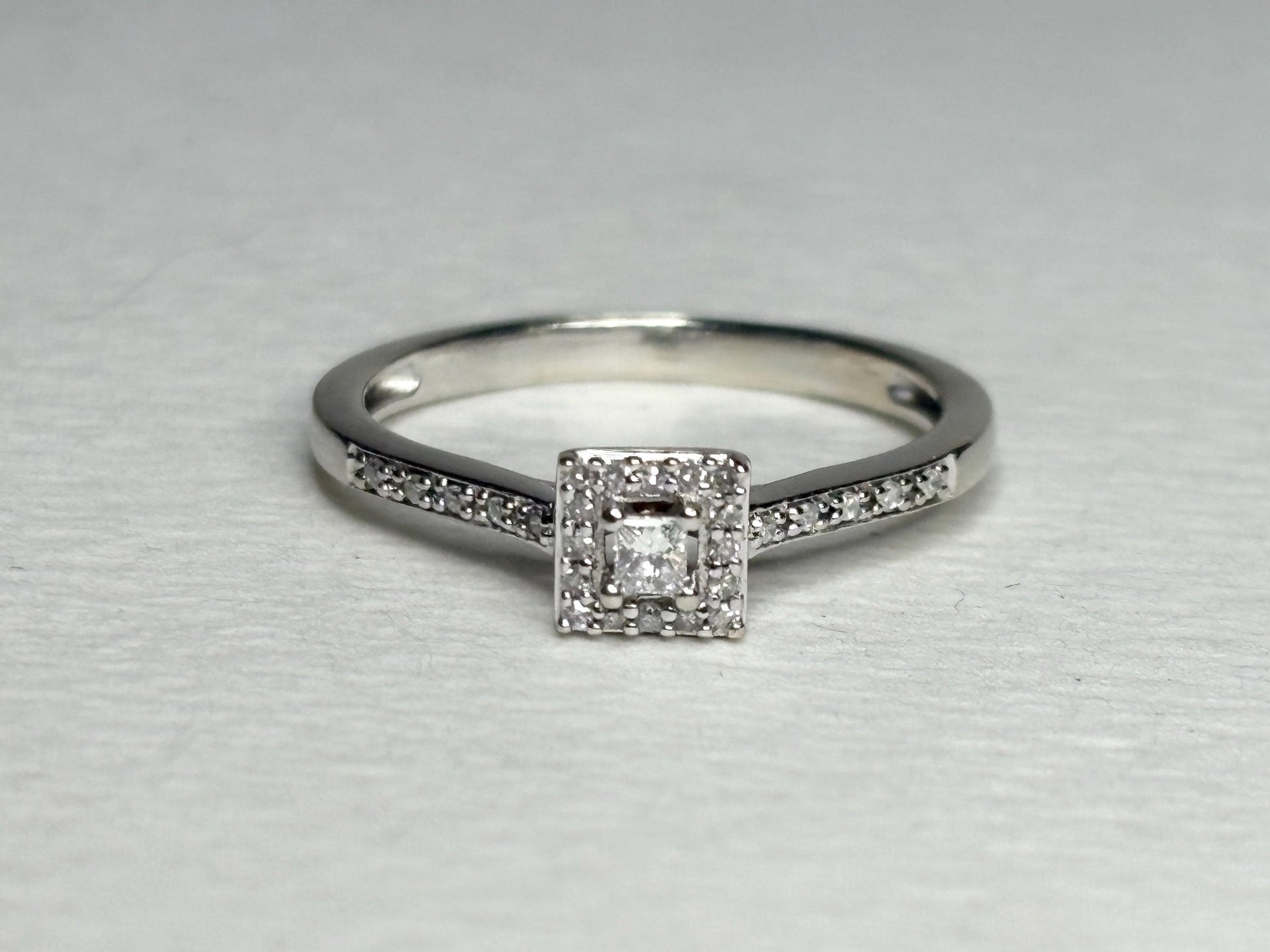 A princess cut diamond halo engagement ring in 10k white gold.