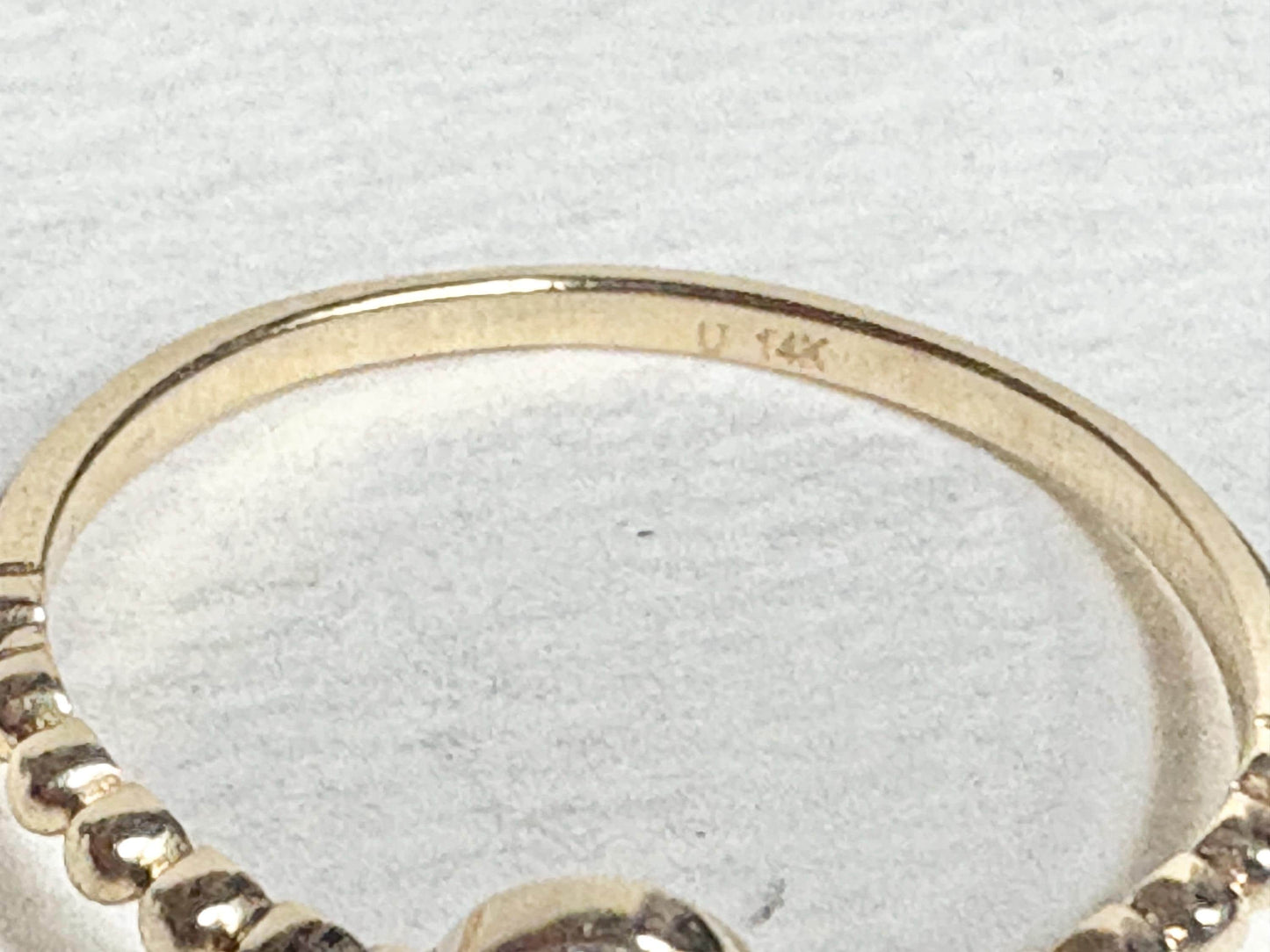 Dainty 14k yellow gold ring with beaded band and pave-set oval stones.