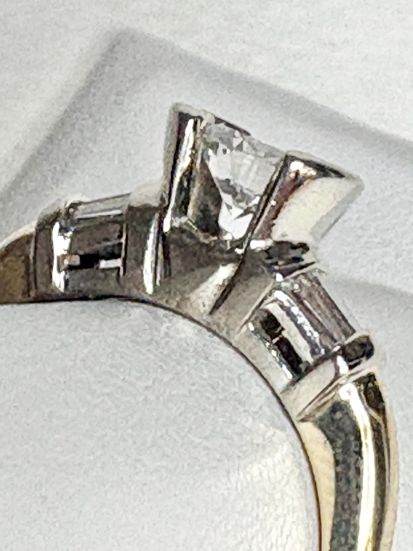 A two-tone 14k gold ring with a half bezel set diamond and channel set baguettes.