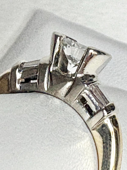 A two-tone 14k gold ring with a half bezel set diamond and channel set baguettes.