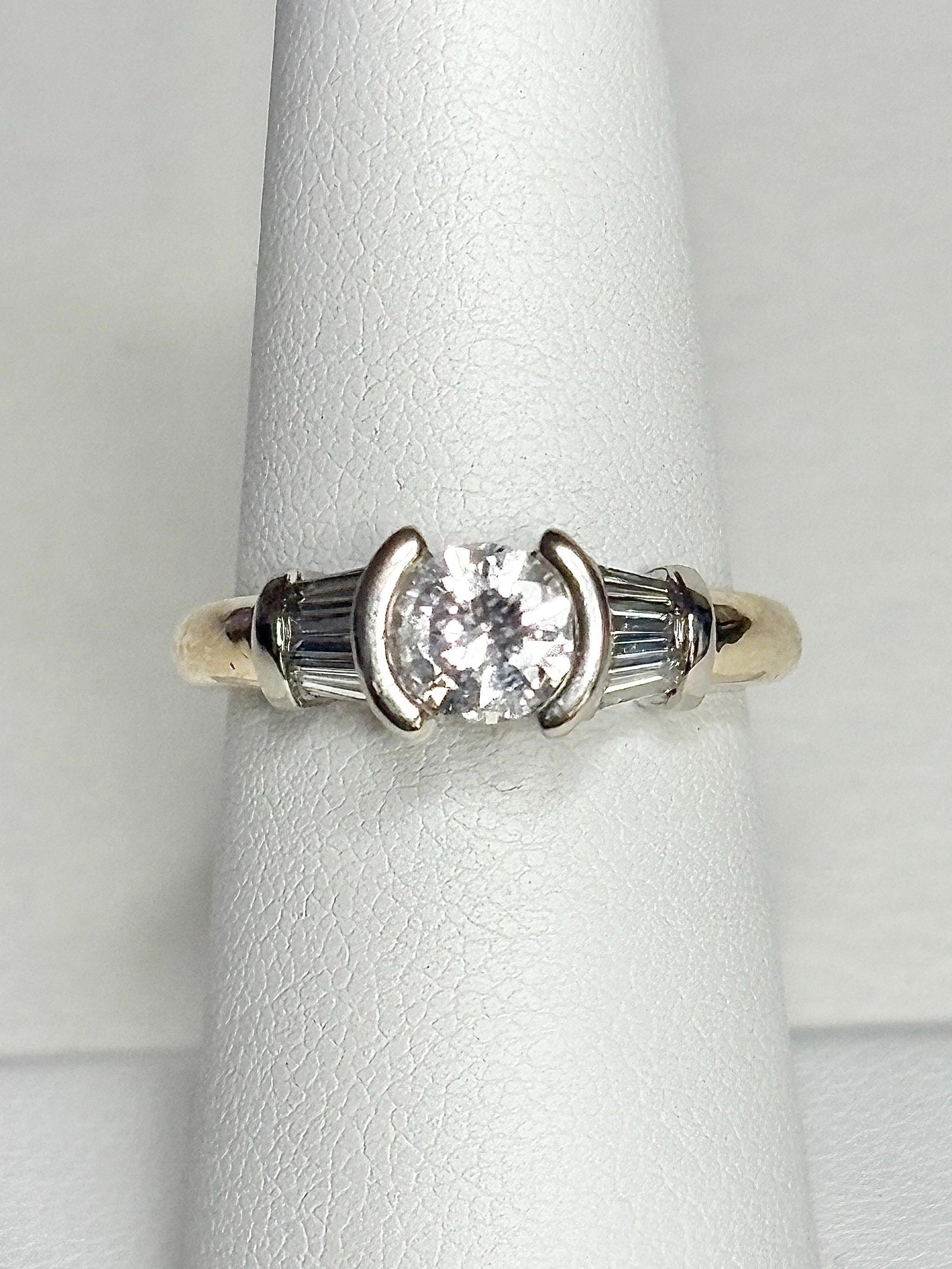 14k gold ring with a round diamond and baguette diamonds.