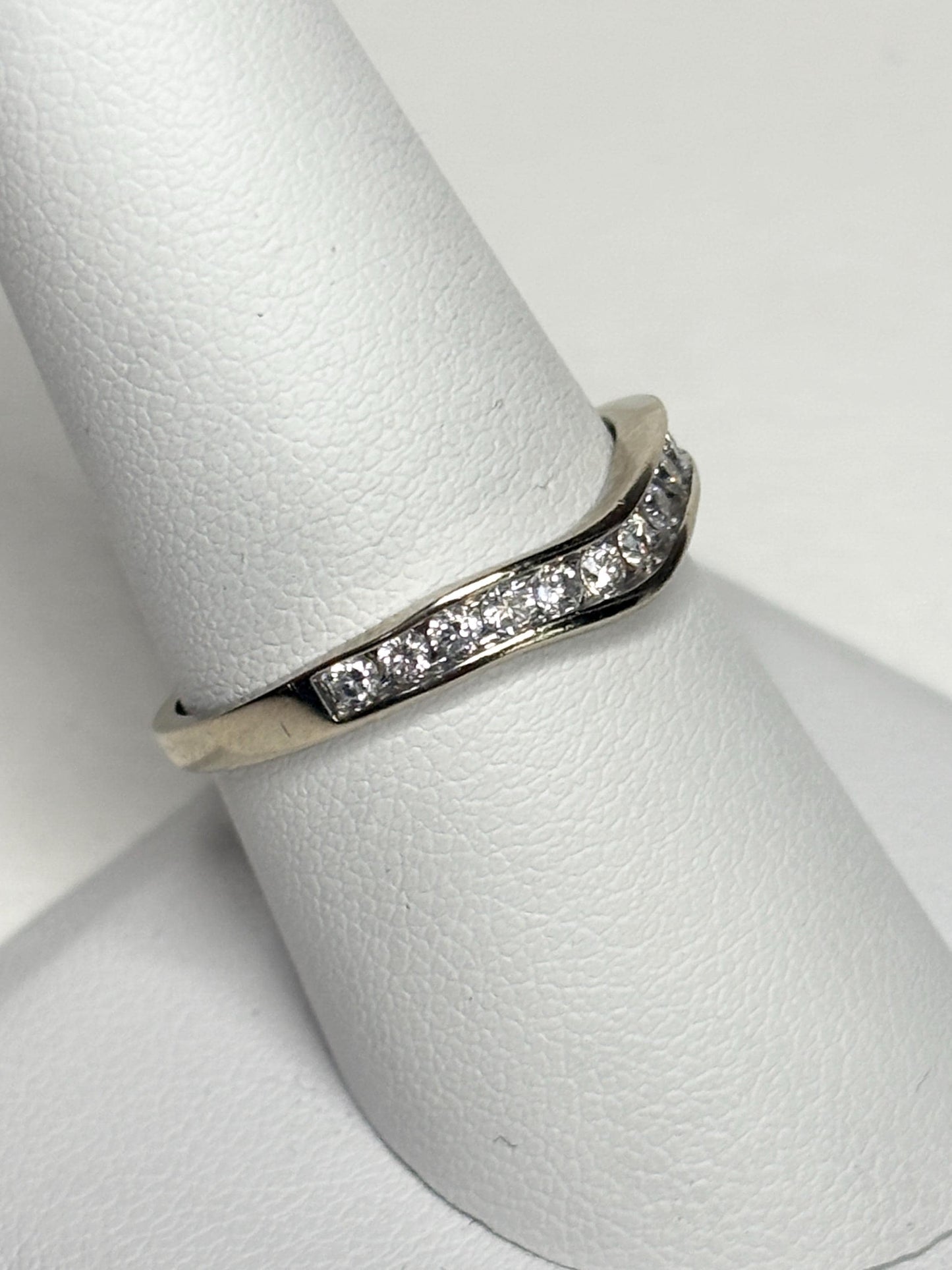 Contoured 14k white gold wedding band with channel-set diamonds.